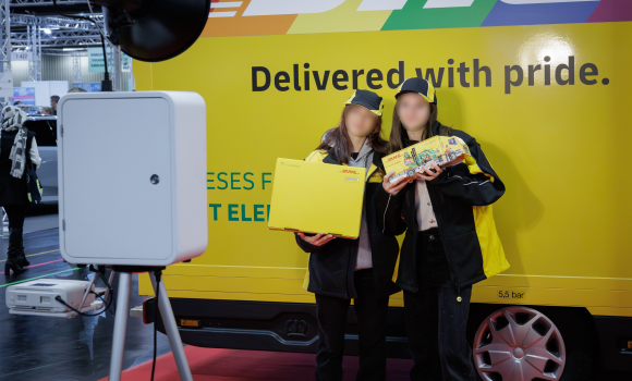 Zwei Mädels posieren beim Fotoshooting vor dem DHL-Truck