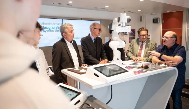 Ein Robotikarm wird den Vertretern der beruflichen Bildung in einer technischen Vorstellung präsentiert.